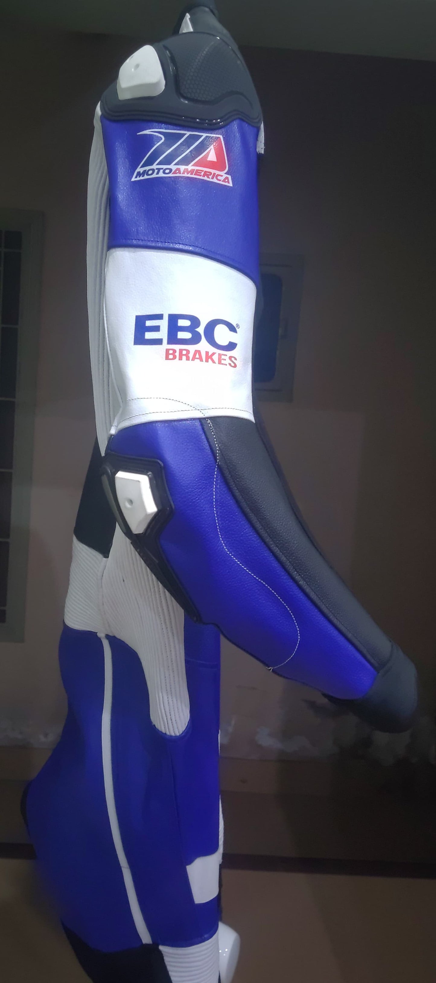 Blue and gray racing glove with EBC Brakes branding on a plain background