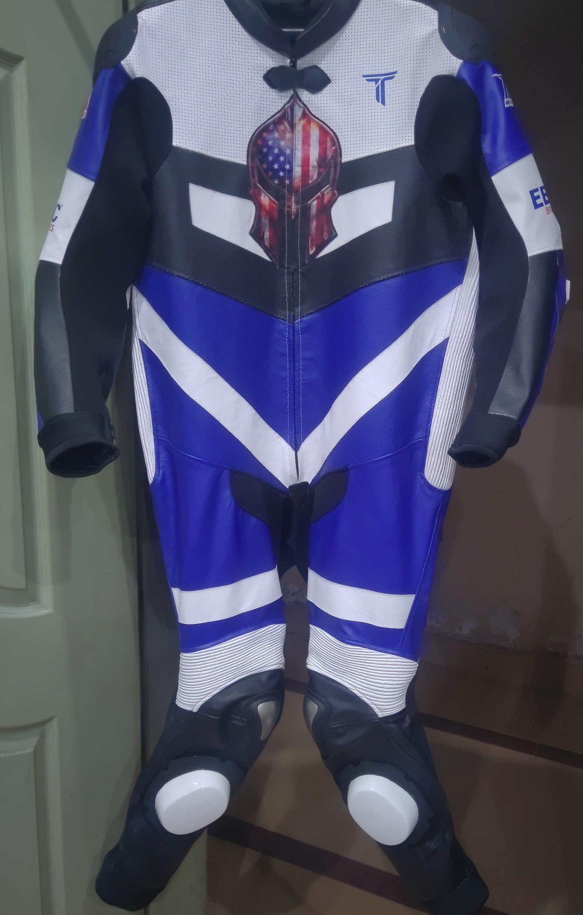 Motorcycle racing suit with American flag design on a plain background