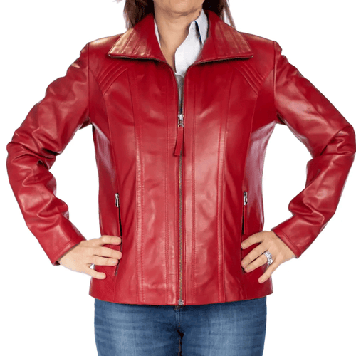 A woman facing forward, wearing a red leather motorcycle jacket with a mandarin collar and zipper details, paired with blue jeans.